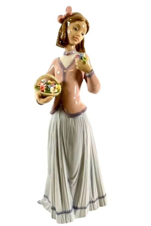 LLADRO INNOCENCE IN BLOOM 1996 SOCIETY PORCELAIN FIGURINE 7644G: LLADRO INNOCENCE IN BLOOM 1996 SOCIETY PORCELAIN FIGURINE 7644GLladró porcelain figurine titled Innocence in Bloom (#7644), depicting a young girl holding a basket of flowers and admiring one in her 