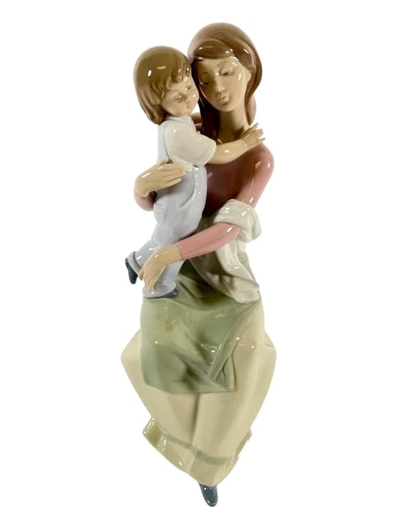 Lladro Limited Edition Porcelain A Mothers Love 6634: Lladro porcelain figurine titled A Mothers Love, model #6634. Depicts a mother seated on a rock, lovingly holding a child in her arms. Measures 11.5 inches tall. The piece is marked on the base with t
