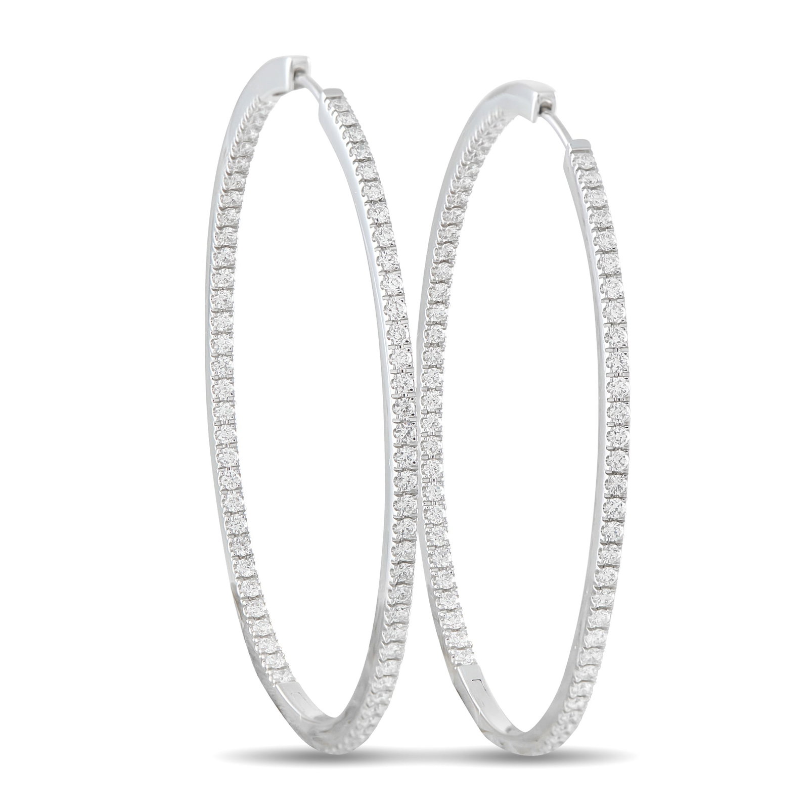 Memoire 18K White Gold 1.45ct Diamond Inside-Out Oval Hoop Earrings: Add a touch of sparkle to any ensemble with these classic Memoire hoop earrings. Simple and elegant, the 18K White Gold settings are elevated by Diamonds with a total weight of 1.45 carats. Each earri