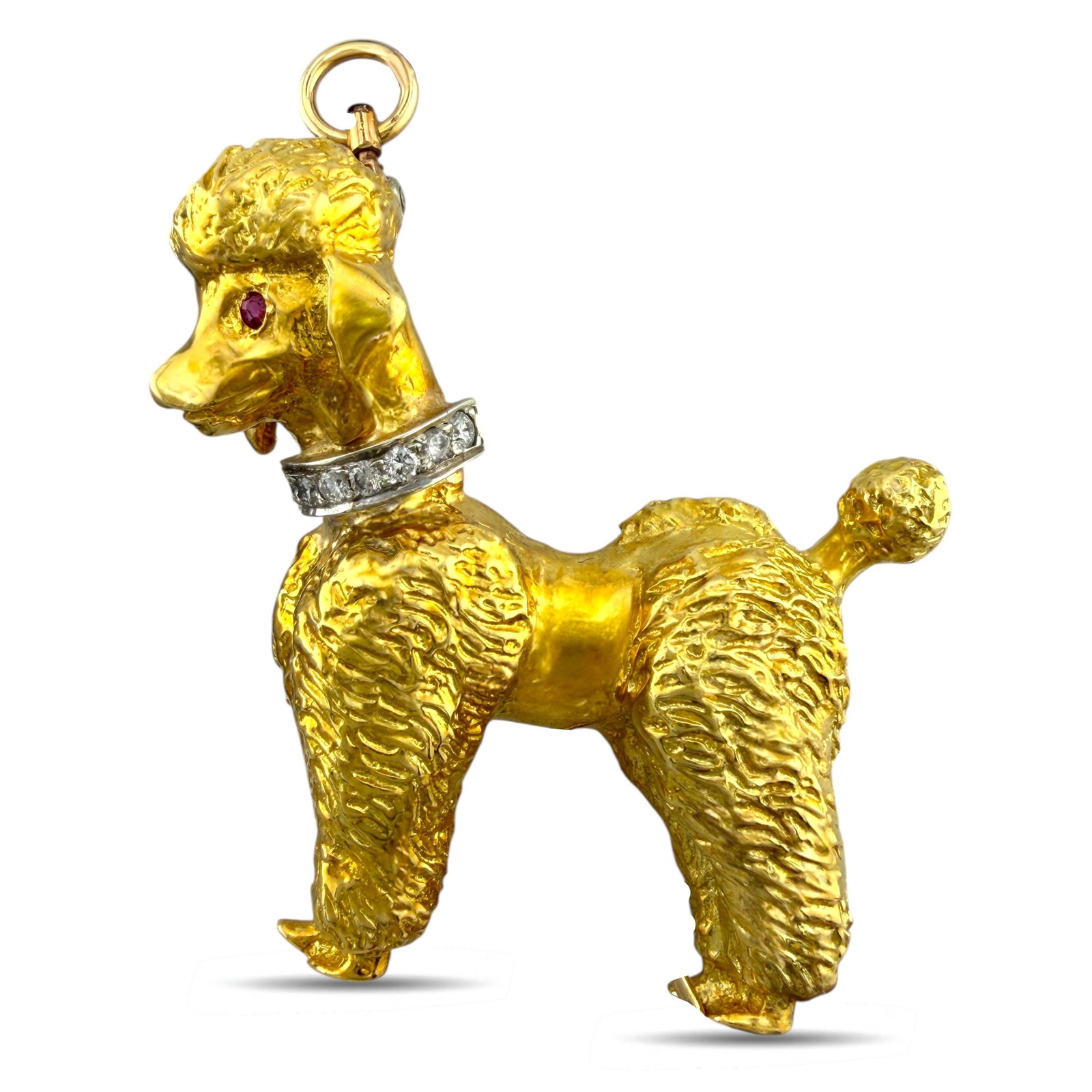 18K Yellow Gold Diamond and Ruby French Poodle Brooch: 18K Yellow Gold 0.1ct Diamond and Ruby French Poodle Brooch A charming and finely sculpted French poodle brooch crafted in rich 18 karat yellow gold. The playful yet refined design captures elegant de