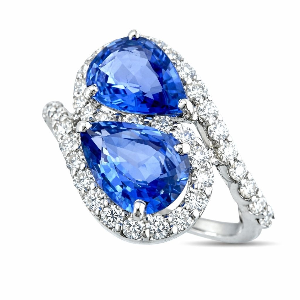 18K White Gold 2ct Sapphire and 0.6ct Diamond Bypass Ring: 18K White Gold 2ct Sapphire and 0.6ct Diamond Bypass Ring An elegant white gold ring designed with a graceful bypass structure where the band interlocks at the top, forming a fluid sculptural composit