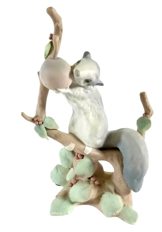 LLADRO DORMOUSE PORCELAIN FIGURINE 01004774 RETIRED: 1983: LLADRO DORMOUSE PORCELAIN FIGURINE 01004774 RETIRED: 1983Lladro porcelain figurine featuring a squirrel grasping a fruit on a tree branch with intricate vine and leaf details. Stands 9 inches tall. Ma