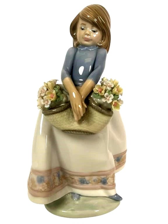 Lladro Porcelain Figurine May Flowers Girl Figurine: Lladro Vintage Limited Edition Porcelain Figurine May Flowers Girl FigurineLladro porcelain figurine titled 'May Flowers Girl,' model #5467. Measures 6.5 inches tall. Depicts a girl holding a basket o