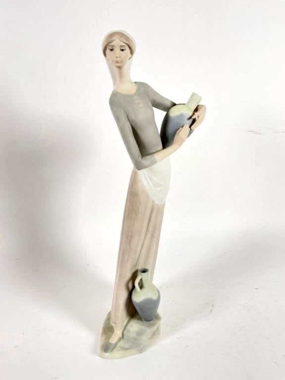 RETIRED: 1985 GIRL W/JUGS LLADRO: LLADRO RETIRED: 1985 GIRL W/JUGSSpanish Name: La Fuente Cantaro Suelo Sculptor: Fulgencio Garcia Year Issued: 1974 Year Retired: 1985Lladro porcelain figurine depicting a girl holding a jug, standing 