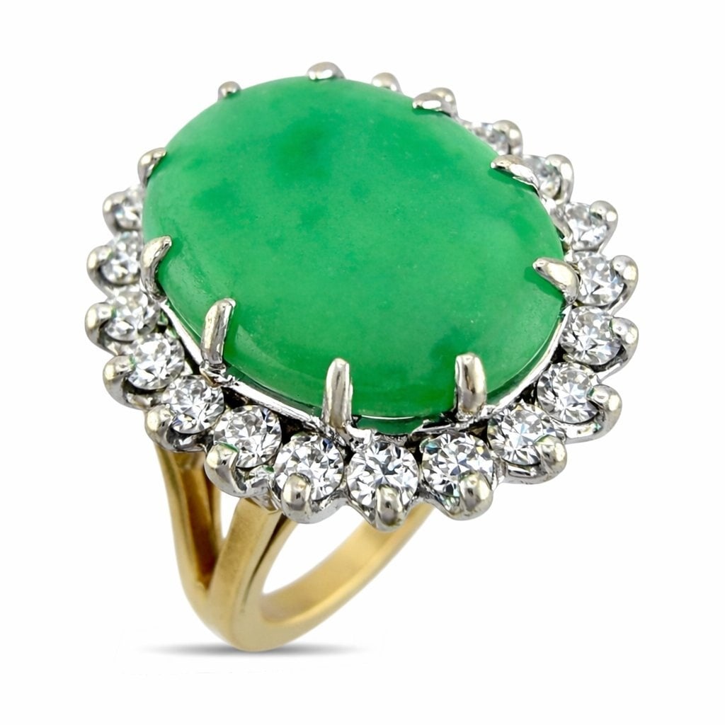 14K Yellow Gold 5.25ct Jade and 0.55ct Diamond Halo Ring: 14K Yellow Gold 5.25ct Jade and 0.55ct Diamond Halo Ring A timeless halo design centered by a luminous oval jadestone, framed by a refined circle of brilliant diamonds. The vivid green cabochon contra