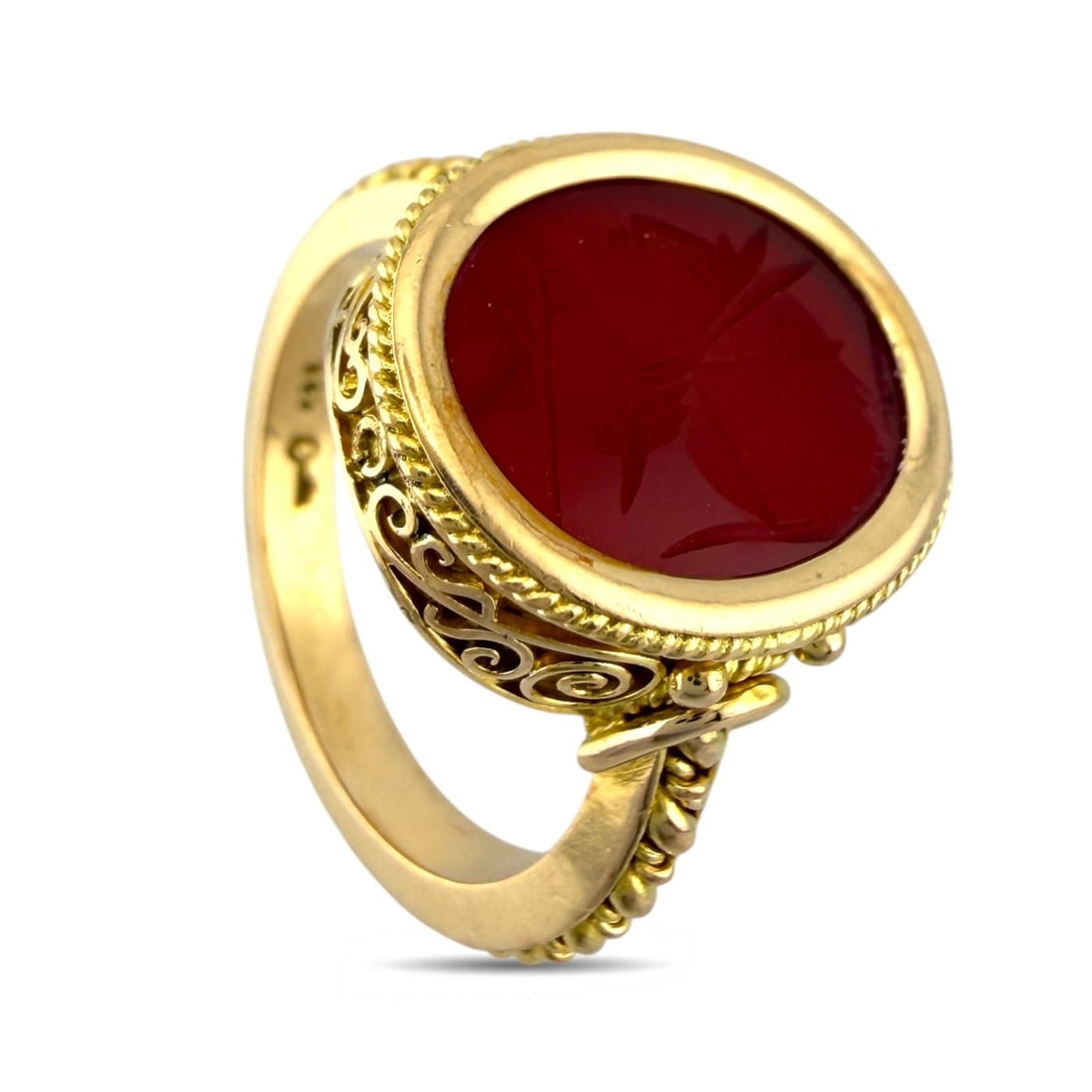 18K Yellow Gold Carnelian Sculpted Face Ring: 18K Yellow Gold Carnelian Sculpted Face Ring A striking and artistic piece featuring a vivid oval carnelian carved with a sculpted face motif. The rich red hue of the stone pairs beautifully with the 