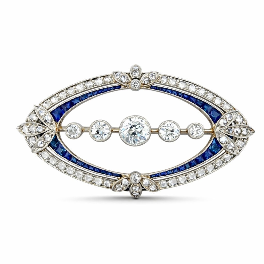 18K White Gold Art Deco 2.05ct Diamond and Sapphire Oval Brooch: 18K White Gold Art Deco 2.05ct Diamond and Sapphire Oval Brooch A refined 18K White Gold Art Deco oval brooch designed with elegant geometric symmetry and a striking inner circle of sapphires. The com