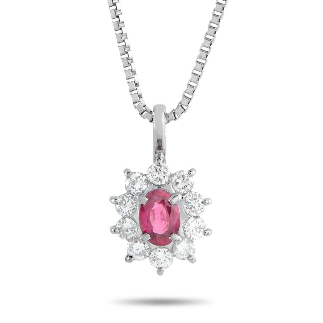 Platinum 0.48ct Diamond and Ruby Pendant: Color and light work in tandem in this piece. At the center, a 0.51-carat oval ruby presents a saturated red tone, secured on four prongs. Around it are 0.48 carats of round diamonds, each set with a 