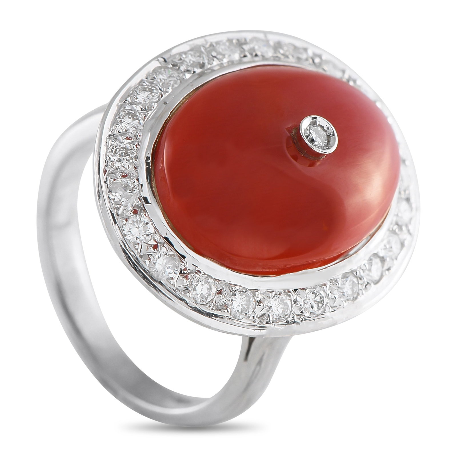18K White Gold 0.65ct Diamond and Coral Ring: A dazzler with a history. This white gold ring, in estate condition, shines with a vintage flair. It is crafted in 18K white gold, topped with a bold oval-shaped coral cabochon. An oval halo of 0.65 c