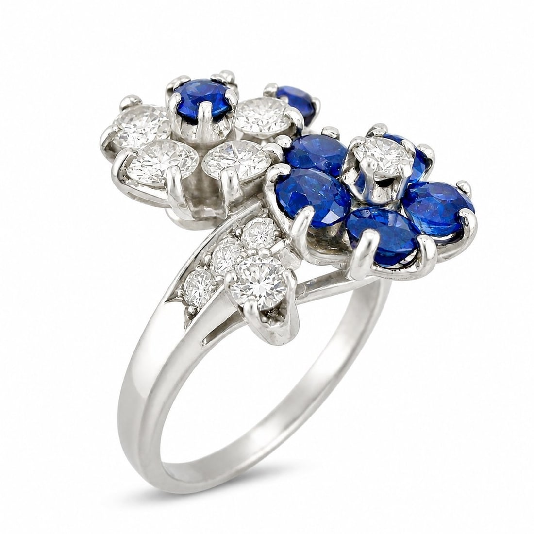 Platinum 1.0ct Diamond and 0.65ct Sapphire Flower Ring: Platinum 1.0ct Diamond and 0.65ct Sapphire Flower Ring A refined platinum flower ring featuring a floral design accented with diamonds and sapphires. The diamond setting includes six larger round