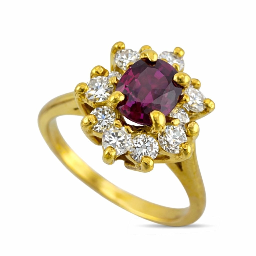 18K Yellow Gold 0.5ct Ruby and 0.24ct Diamond Cocktail Ring: 18K Yellow Gold 0.50cy Ruby and 0.24ct Diamond Cocktail Ring A classic cluster design crafted in rich 18K yellow gold, centering a vivid oval ruby embraced by a radiant halo of brilliant diamonds.