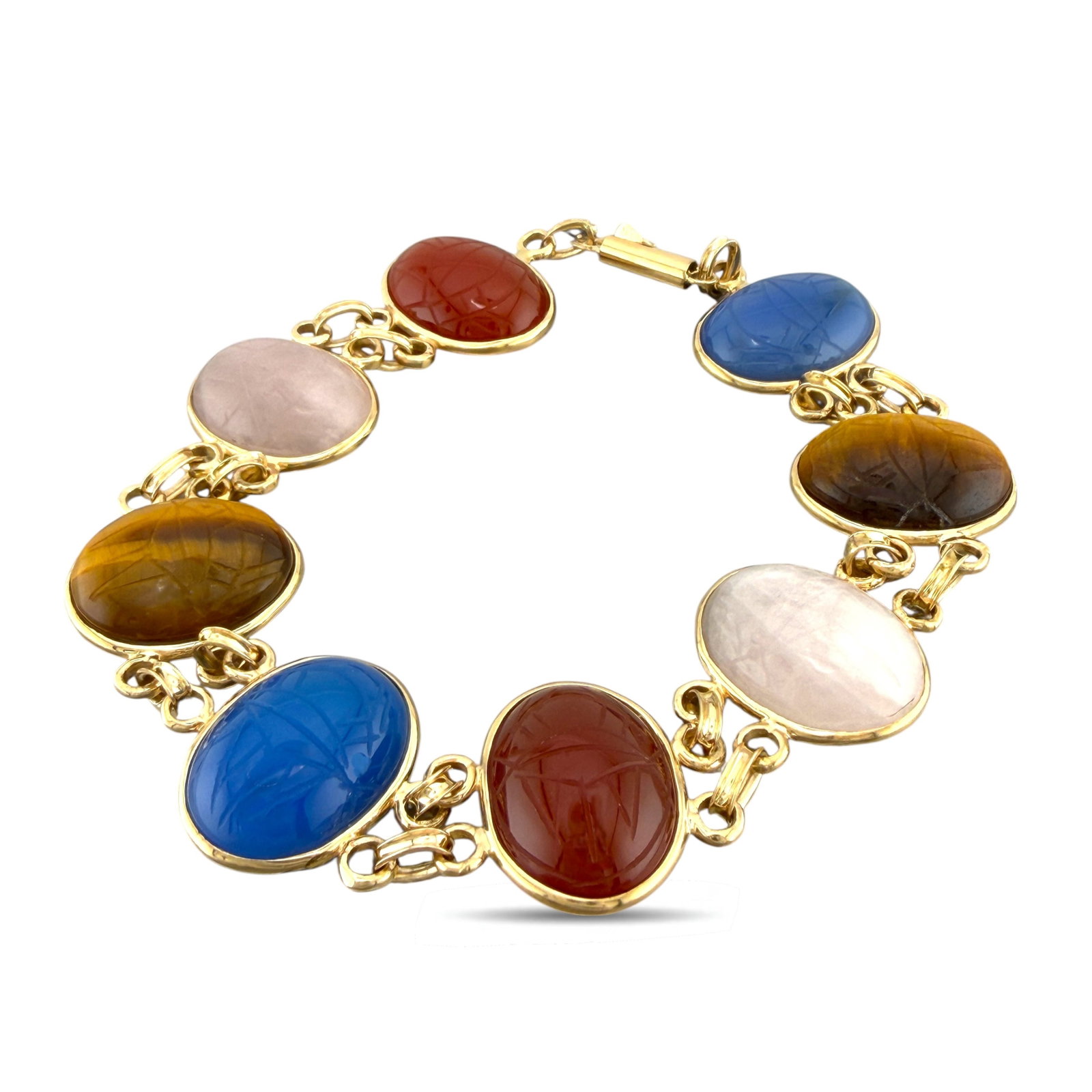 18K Yellow Gold Oval Multi-Gemstone Bracelet: 18K Yellow Gold Oval Gemstone Bracelet Crafted in 18K yellow gold, this piece features cabochon sapphires and rubies set within a warm and luminous gold framework. The smooth domed gemstones enhance t