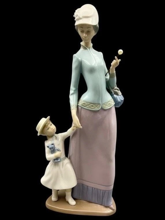 Lladro #1353 Lady with Girl Figurine -: Lladro #1353 Lady with Girl FigurinePorcelain figurine by Lladro, model #1353, depicting a lady holding an umbrella and a child holding her hand. Finished in soft pastel tones with intricate detailing