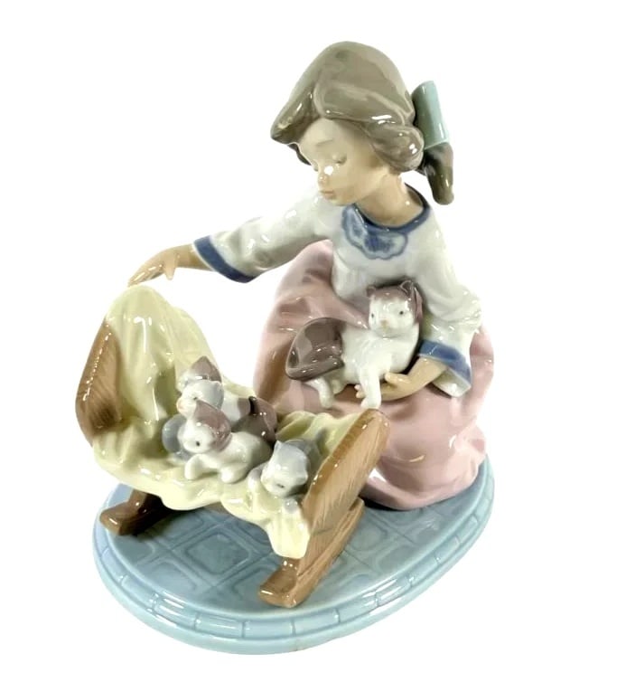 LLADRO A CRADLE OF KITTENS 1991-97 PORCELAIN FIGURINE 5784G: LLADRO A CRADLE OF KITTENS 1991-97 PORCELAIN FIGURINE 5784GLladro porcelain figurine #5784 titled Cradle of Kittens, featuring a young girl tending to a cradle of kittens with one in her lap. Hand-pai