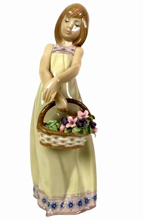 LLADRO FLORAL TREASURES PORCELAIN FIGURINE 5605: LLADRO FLORAL TREASURES PORCELAIN FIGURINE 5605Lladro 'Floral Treasures' porcelain figurine #5605, depicting a young girl in a flowing dress holding a basket of flowers, finished in a glazed pastel co