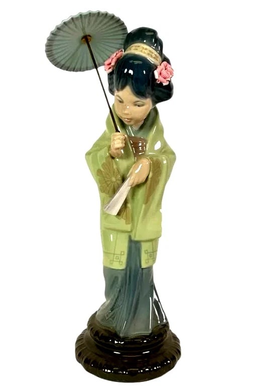 LLADRO ORIENTAL SPRING 1978-96 PORCELAIN FIGURINE 4988G: LLADRO ORIENTAL SPRING 1978-96 PORCELAIN FIGURINE 4988GLladro porcelain figurine titled 'Japanese Geisha Girl with Umbrella,' model number 4988. Standing 10.5 inches tall, the piece depicts a geisha h