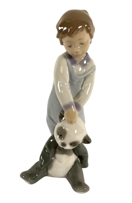 Lladro Porcelain First Discoveries 6974: Lladro Porcelain First Discoveries 6974Porcelain figurine titled First Discoveries by Lladro, depicting a boy playing with a panda. Stands 6 inches tall. Glossy finish with hand-painted details. Marke