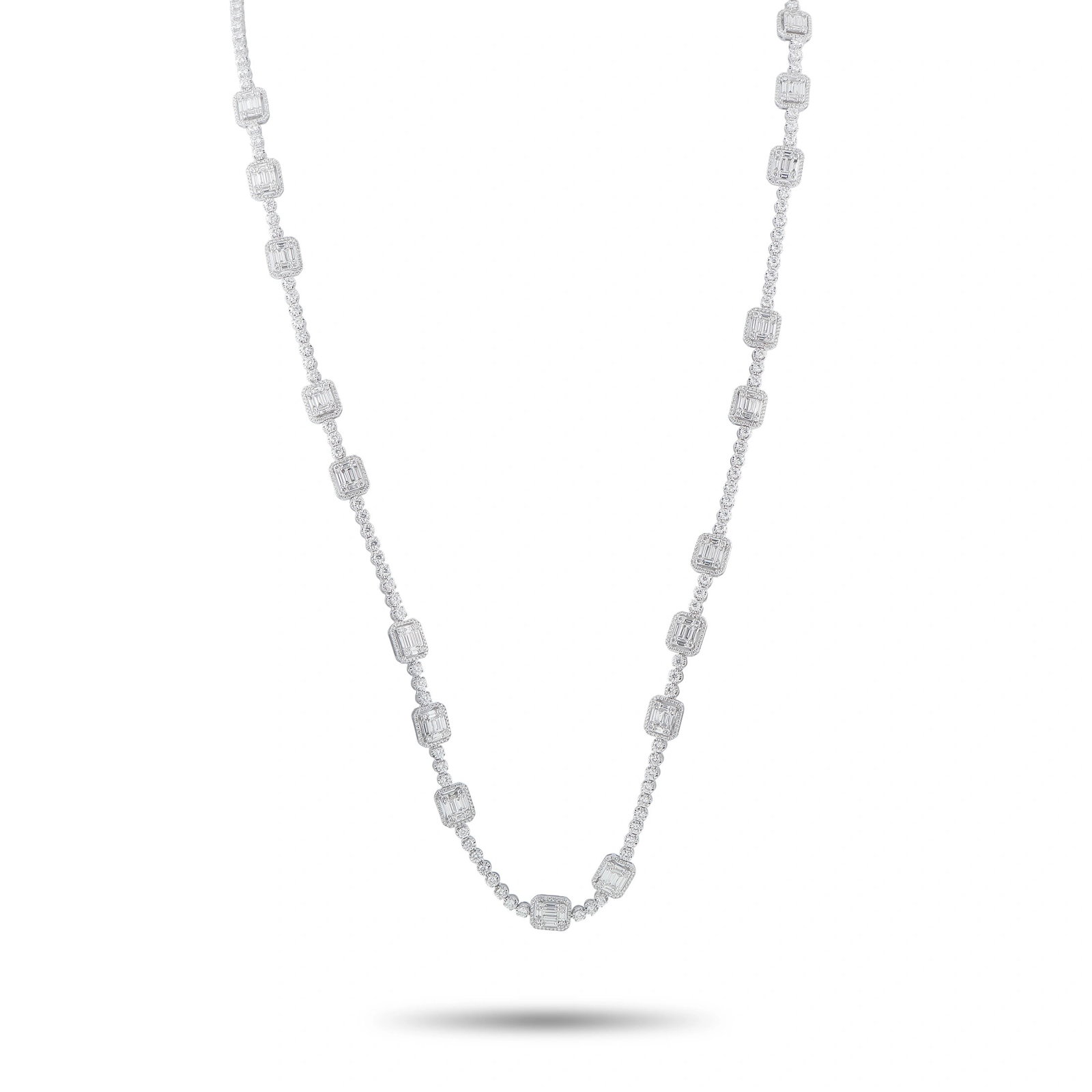18K White Gold 29.85ct Diamond Station Necklace: This estate necklace is crafted in 18K white gold and features a continuous line of round diamonds punctuated by emerald and baguette-cut diamond cluster stations, totaling approximately 29.85 carats.