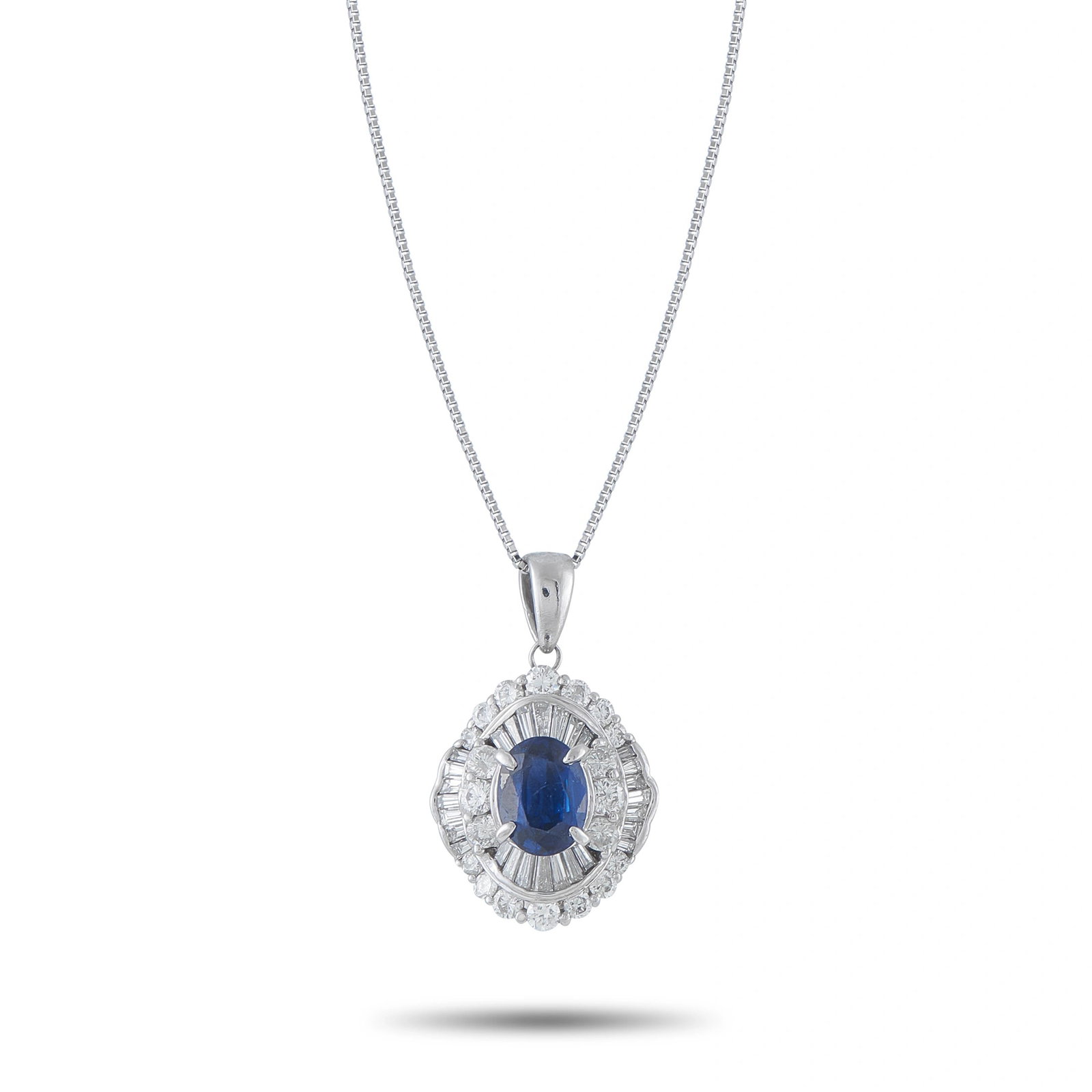 Platinum Sapphire and Diamond Double Halo Pendant: A classic halo pendant in platinum, featuring a vivid oval blue sapphire at center surrounded by a double halo of baguette and round diamonds — 4.05 ct total gem weight. Suspended on a 17? platinum 