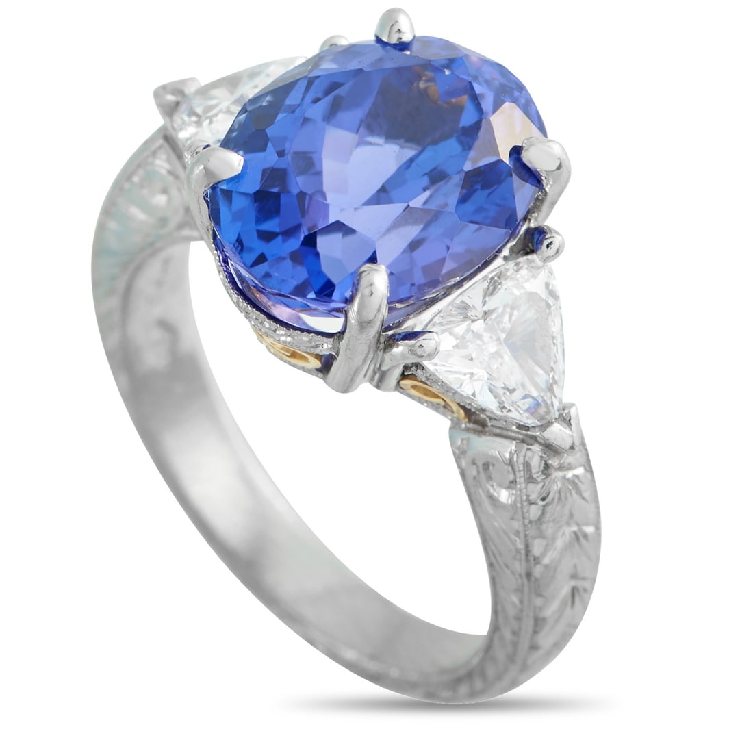 Platinum and 18K Yellow Gold 0.95ct Diamond and Tanzanite Ring: A mix of period cues, brought into a single composition. The platinum band features a squared profile, its three outer faces engraved with a wheat-like motif. Polished surfaces remain visible between 