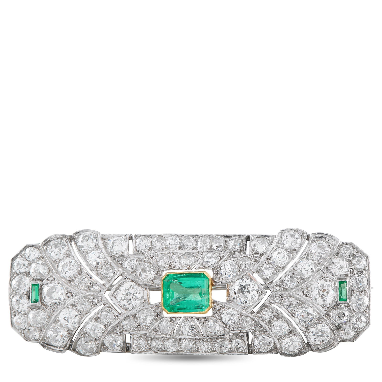 Platinum 5.30ct Diamond and Emerald Art Deco Brooch: Symmetry defines this Art Deco platinum brooch. At the center rests an emerald set in a yellow gold bezel, introducing a deliberate contrast. On the same horizontal line, two smaller baguette-cut emer