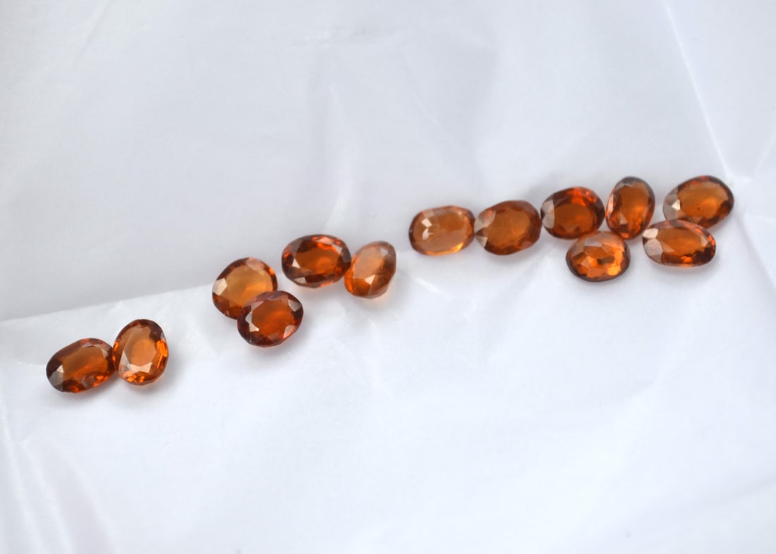 12.93 Carats of Oval Cut Hessonite Garnet: Fine examples of this rarer form of Garnet. Great color and good clarity. Natural and untreated. These were originally meant to be sold individually at the price per carat written on the paper. We're