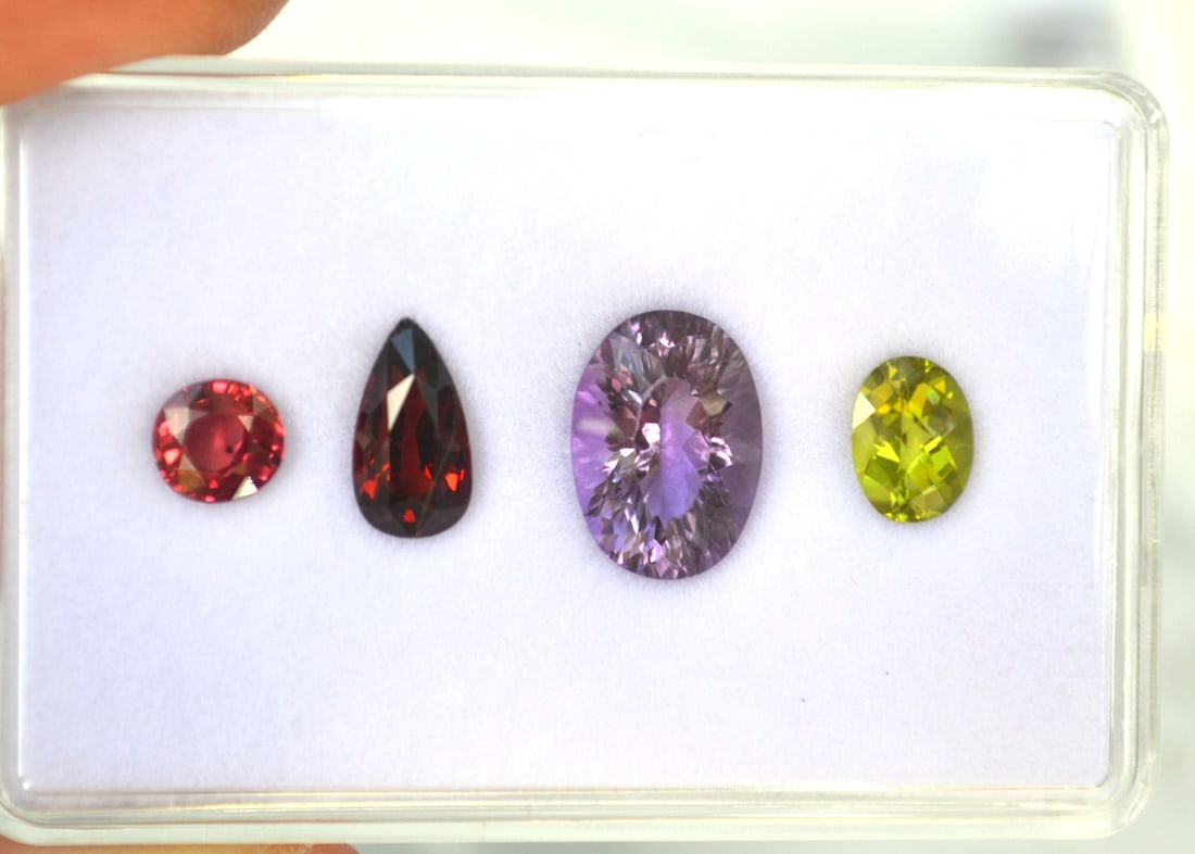 9.85 Carats of Jewelry Grade Mixed Gems: High grade set of gemstones. Included is a 2.35 carat Rhodolite Garnet, a 4.90 carat Amethyst, a 1.40 carat Peridot and a 1.20 carat color enhanced Sapphire. All high quality, colorful stones with