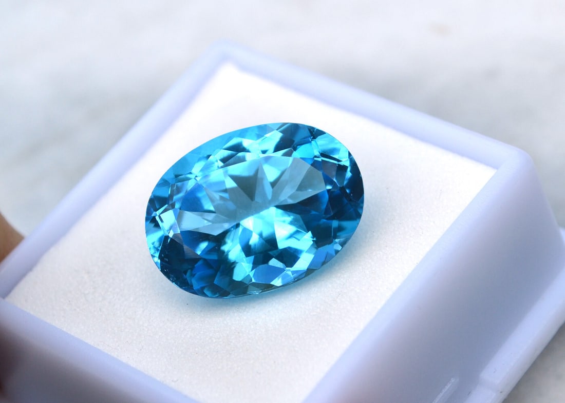 15.17 Carat Oval Cut Swiss Blue Topaz: Fine Blue Topaz. Natural stone but heated and irradiated to get its color, as all Blue Topaz are. This is an industry accepted practice applied to all Blue Topaz. For Proxibid bidders, shipping is a f