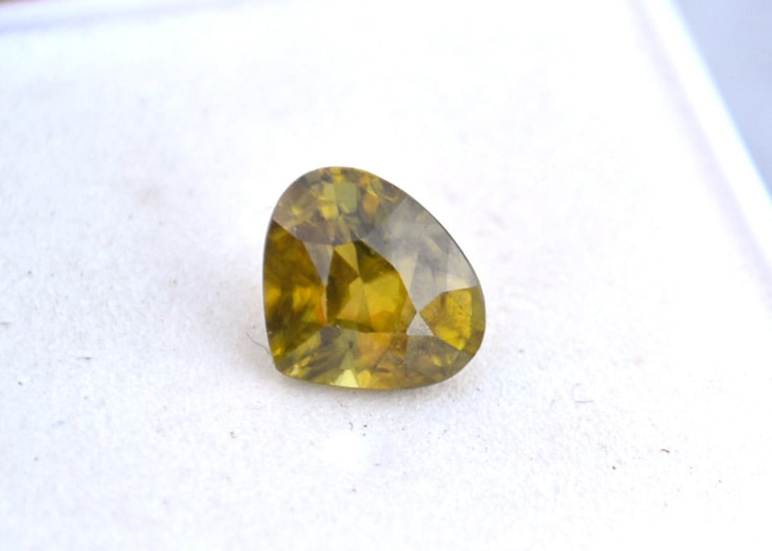 1.88 Carat Pear Cut Sphene: Beautiful example of this rare form of gemstone. Sphene has twice the fire of Diamond and this stone has strong flashes of green and red in direct sunlight. These flashes are easier to capture photogr