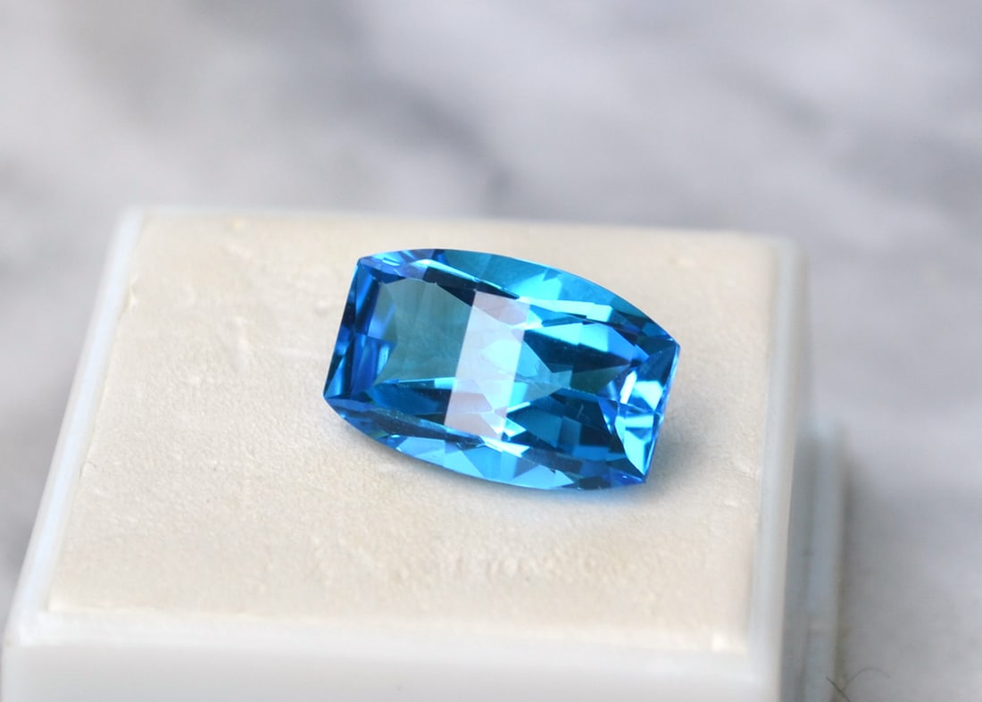 10.86 Carat Fancy Bar Cut Swiss Blue Topaz: Beautiful Topaz with a great fancy cut. Perfect for use in jewelry. Natural stone but heated and irradiated to get its color, as all Blue Topaz are. Most gems sold online aren't jewelry grade.