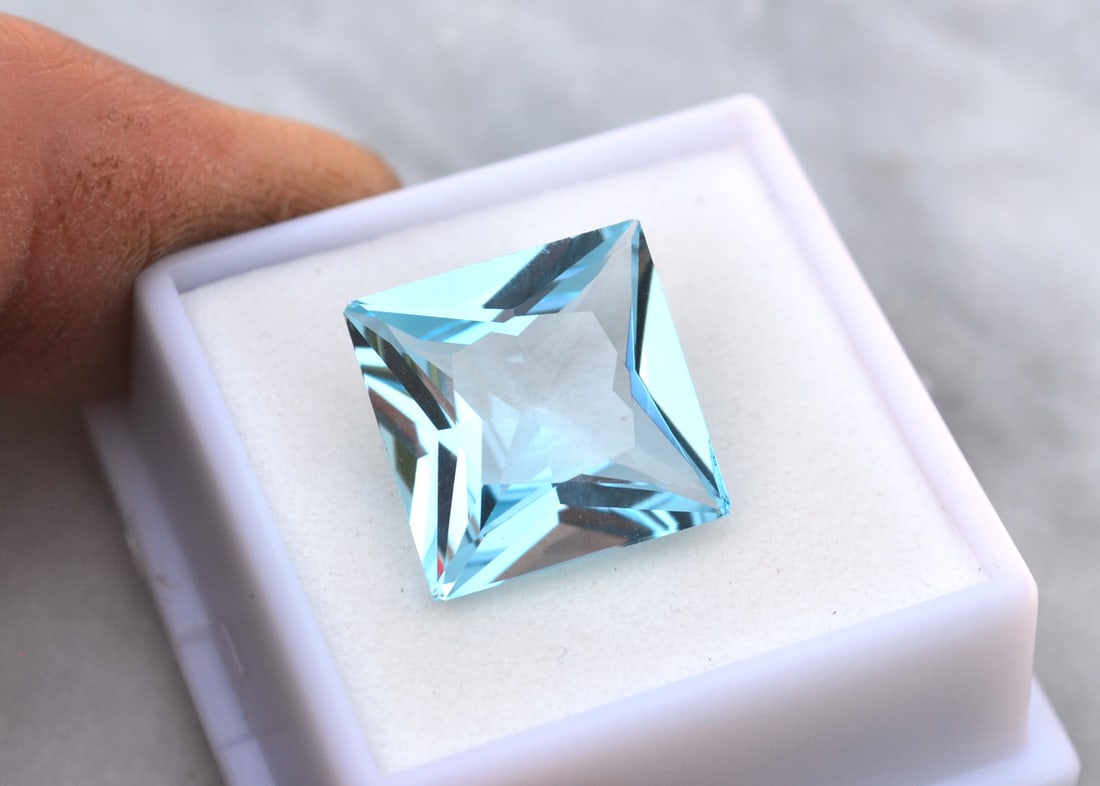 14.63 Carat Princess Cut Sky Blue Topaz: Beautiful Topaz with a great princess cut! All Blue Topaz are heated and irradiated to get their color. This is an industry accepted standard applied to all Blue Topaz. Natural stone. Most gemstones