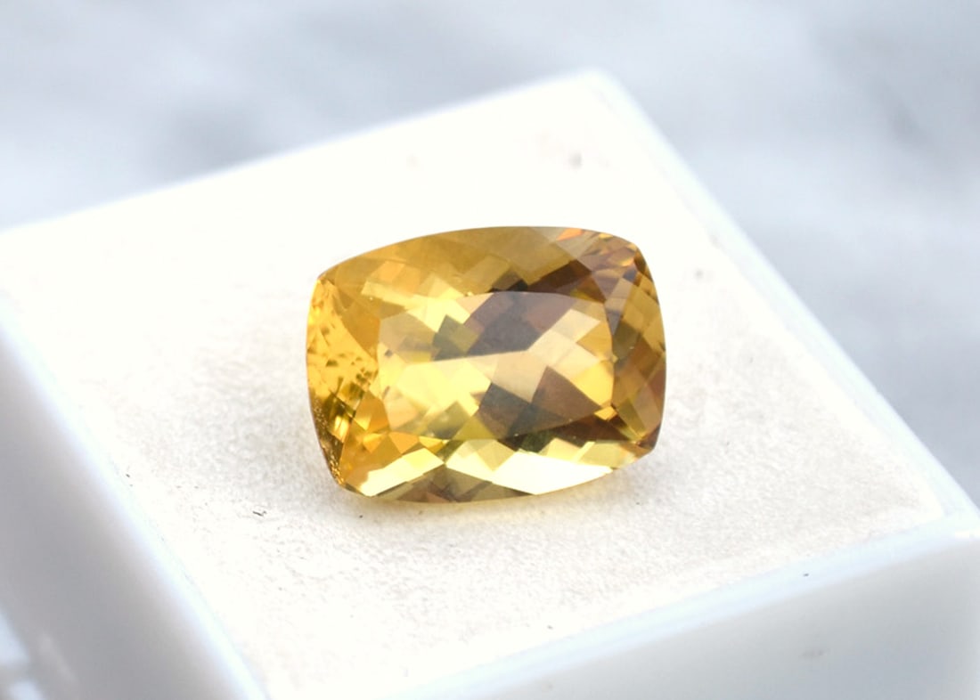 8.78 Carat Cushion Cut Heliodor: Beautiful example of a Heliodor. Fantastic color and cut. Has a minor inclusion, which is reflected in the price. Heliodor is in the Beryl family, along with Emerald and Aquamarine. So, as you can