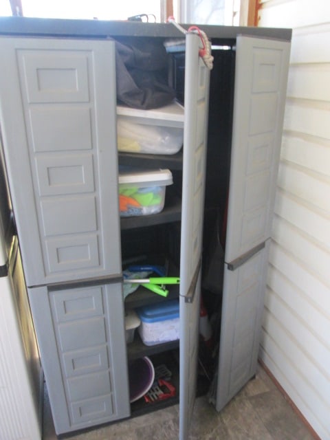 Black Heavy Duty Plastic Triple Door Storage Cabinet and Contents: 40" x 16" x 65", cleaning products, cabinet blew over and needs to be snapped back together on back/right side, Local Pickup Only