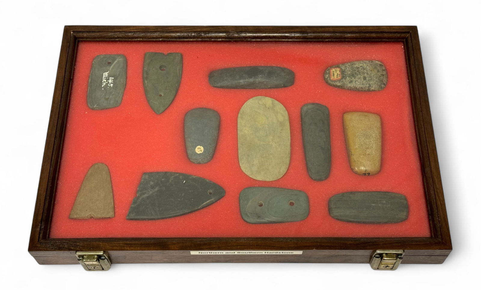 12pc. Curated Ancient Native American Northern and Southern Hardstone Artifacts Cased Display: 12 pieces in total of hardstone pendants, gorgets, and celts. Case Measures 18” x 12” and comes with Key. From Northern and Southern regions.