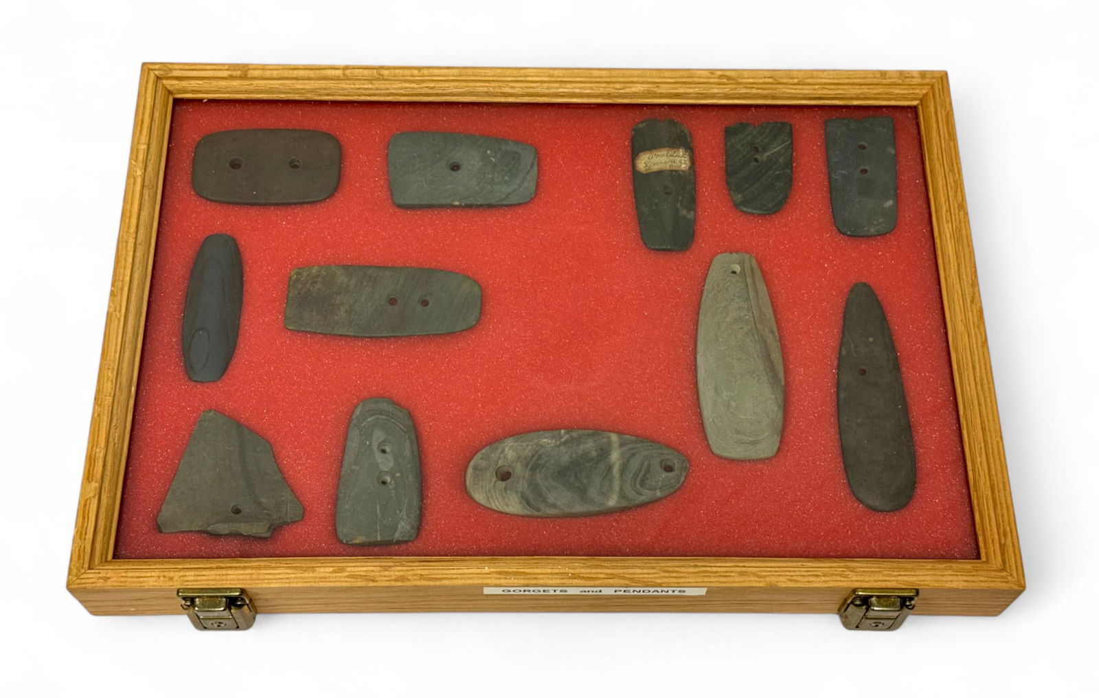 12pc. Curated Ancient Native American Slate / Hardstone Gorgets & Pendants Cased Display: 12 pieces in total of nice Slate & hardstone pendants and gorgets mostly from Ohio, VA, Michigan, etc. Some partial. Case Measures 18” x 12” and comes with Key.
