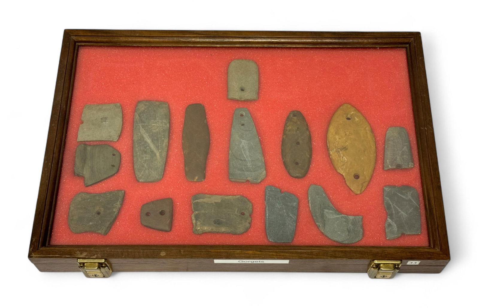 15pc. Curated Ancient Native American Slate / Hardstone Gorgets & Pendants Cased Display: 15 pieces in total of Slate pendants mostly from VA, OH, Michigan. Contains Partial and whole, drilled/undrilled. Lots of variety with stone types with this one. Case Measures 18” x 12” an