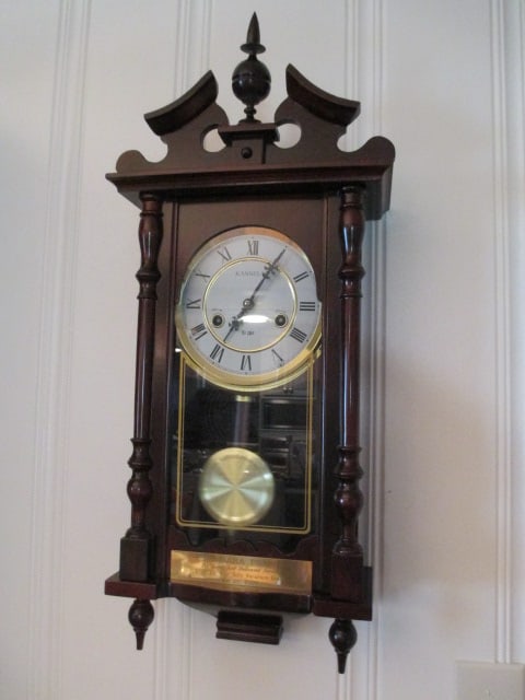 Presentation Kassel 31 Day Regulator Wall Clock: 12 1/4" x 5 3/4" x 27 1/2"(to top of split pediment finial), has key and pendulum, winds, ticks and chimes, has brass Years of Service presentation plate on door, Local Pickup Only