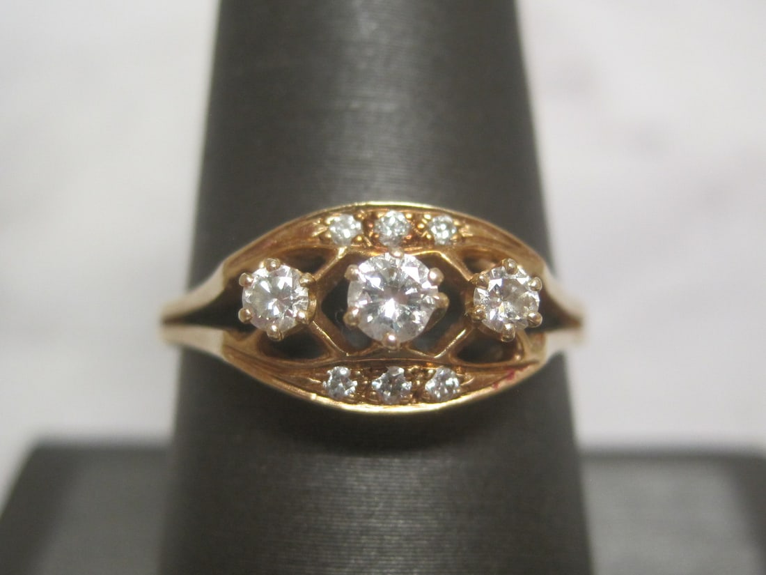 14k Gold Diamond Ring: 9 Round diamonds totaling over 1/4 carat. Size 9. Weighs 3 grams