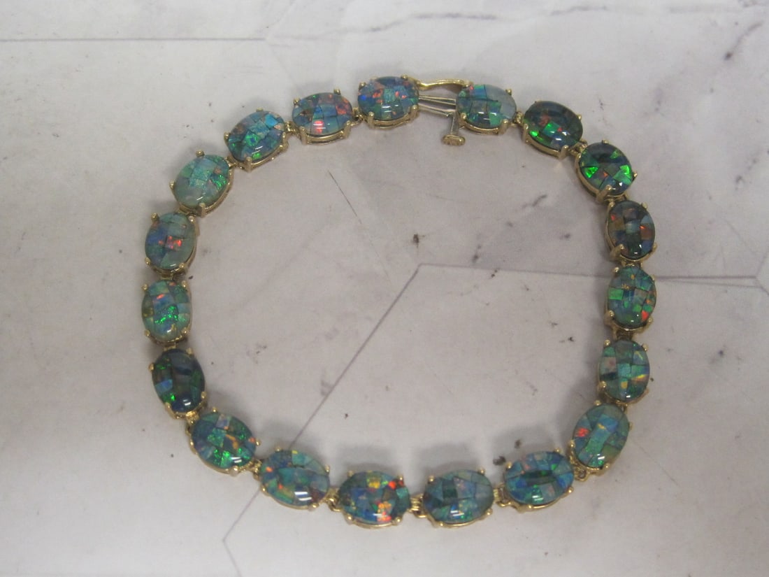 7" Gorgeous 14k Gold Black Opal Mosaic Bracelet: 19 Oval Cabachon doublet black stones. Weighs 10 grams