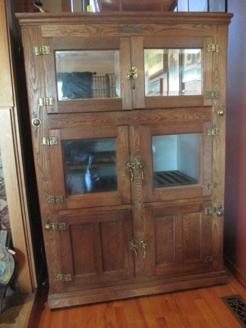 Large Alaska Muskegon Mich, USA Antique Oak Ice Box: 47 1/2" x 32" x 69", top section has been converted to dry bar, beveled mirror upper doors, glass center doors and solid wood bottom doors, lights have been added to upper section, Bring Additional He