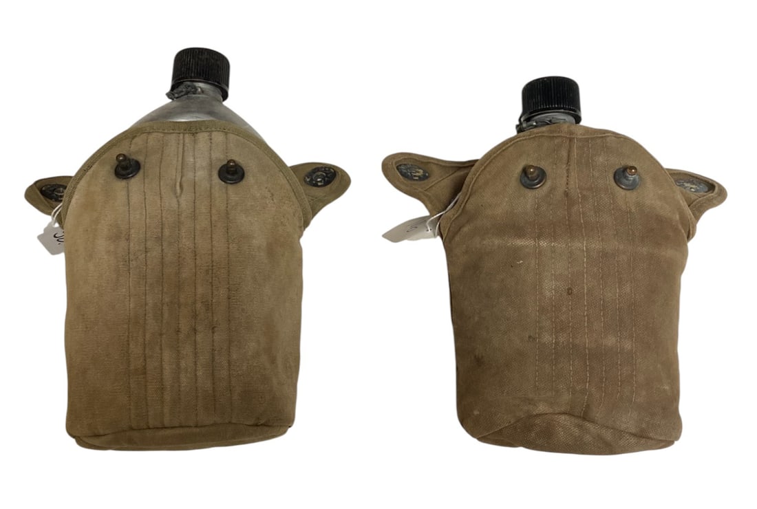 (2) Complete WWII US Canteen Sets: (1) Kit Hard to Read Case, 1945 SM Co Mess Cup with an interesting Brass Clasp, and 1945 AGM CO Canteen. (1) kit has a hard to read case, 1944 SM CO Mess Cup, and a 1944 SM CO Canteen.