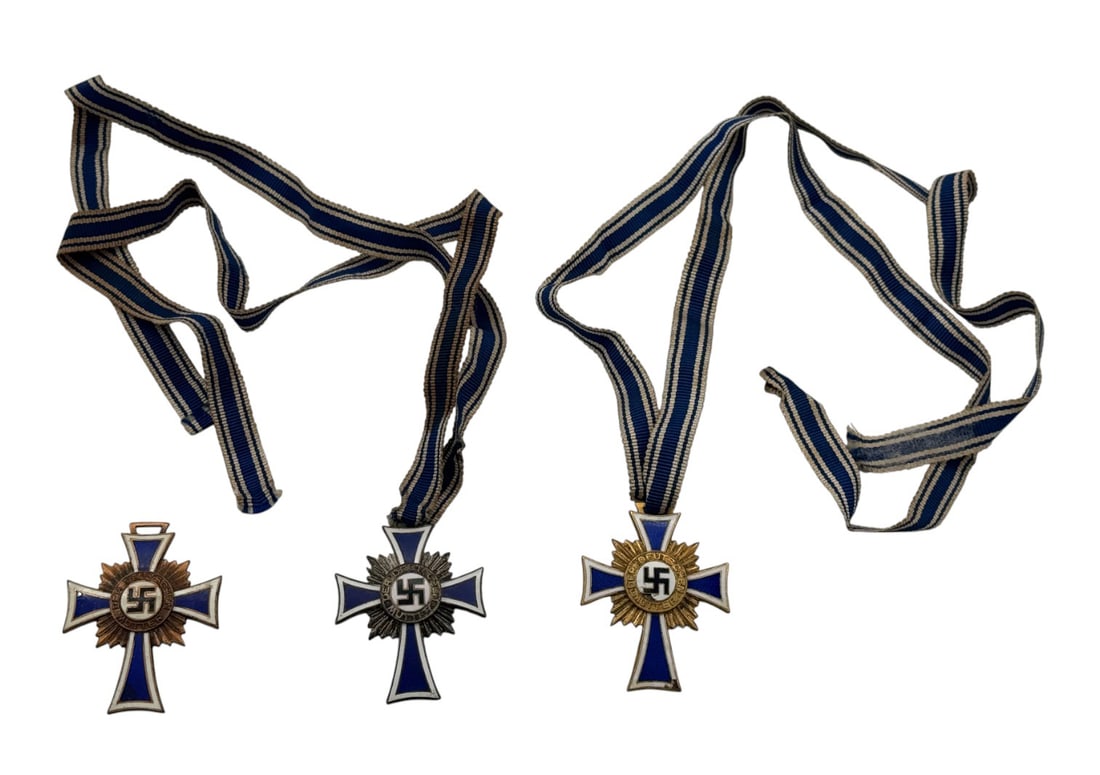 German WWII Full Size Gold, Silver and Bronze Mother's Cross Awards w/ Ribbons: The bronze example does not have the ribbon. The gold medal shows some enamel chipping to the lower arm and in center. The silver and gold examples both have the original ribbons. Highly collectible p