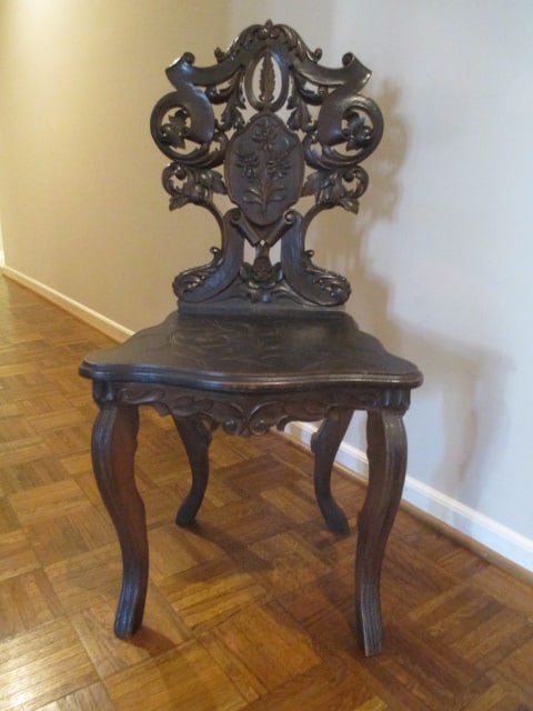 Antique 18th Century Intricately Carved German Black Forest Musical Chair: Musical mechanism has been removed and seat is screwed shut, heavily carved scrolling leaves and flowers in shield backrest, seat has carved floral designs, 18 1/2"w, Local Pickup Only 