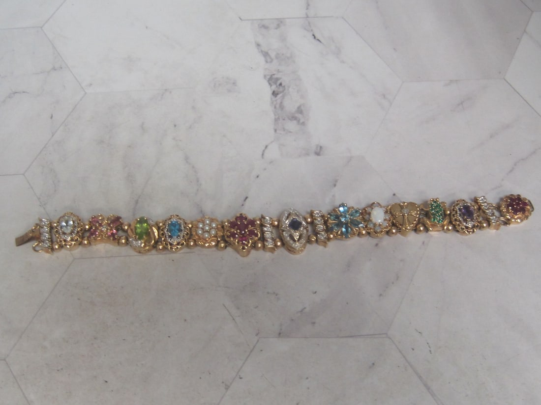 7" 14k Gold Richard Klein Slide Charm Bracelet: Including 17 slides & gold bead spacers. Stones include diamonds, emeralds, rubies, topaz, amethyst, opals, pearls, peridot, & more 