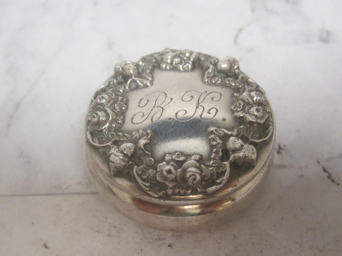 Victorian Sterling Silver Patch Box or Pill Box: Weighs 13.5 grams, 1 1/4" diameter, Art Nouveau cherub & floral, pendant or chatelaine loop, Inscribed "BK" on top & "Christmas '93 Love Ron" on bottom