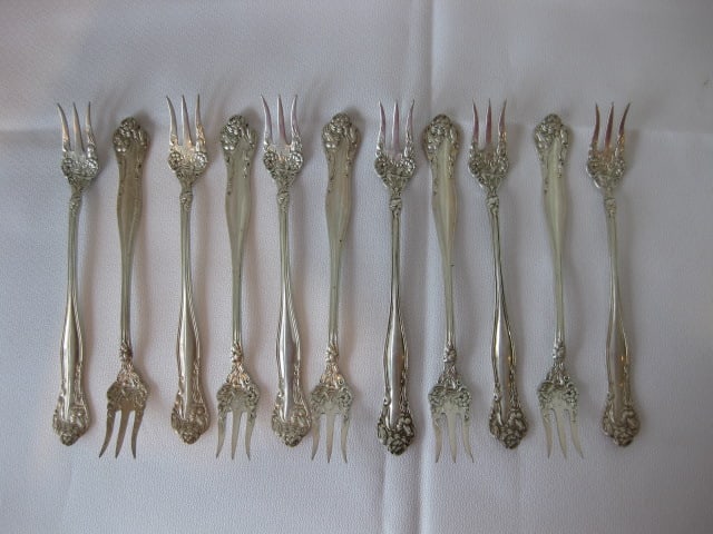 11 Vintage Victorian Sterling Relish Forks with Floral Design: 5.98 troy ounces total weight, each measures 5 3/8" long, marked with Griffin symbol and Sterling Pat.