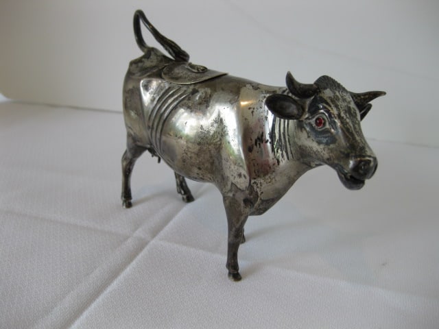 Sterling Cow Form Creamer: 6.64 troy ounces, has red glass(?) eyes, marked with walking lion on bottom