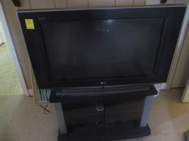 LG TV & Stand & Remote: Powers on; TV screen (30 inch); Cabinet with glass doors (17" x 30" x 16-1/2"); cabinet on wheels