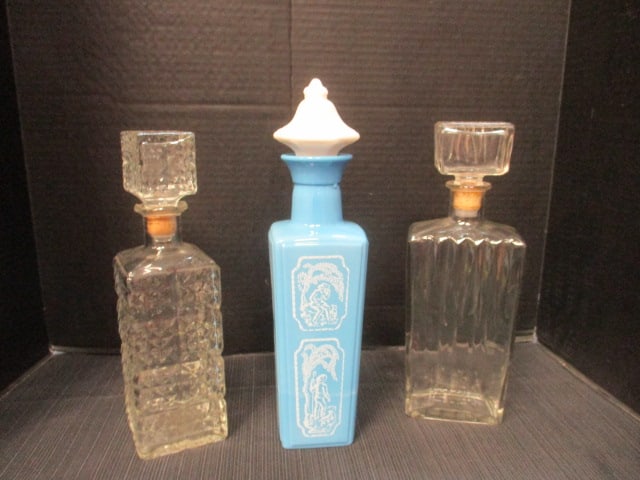 Three Midcentury Liquor Decanters: Diamond point design 11"h, Spike design 11 1/2"h, Blue milk glass with white stopper 12 1/2"h