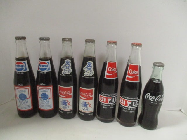 Grouping of 7 Unopened Commemorative Coca-Cola Bottles - Furman, Olympics,: and Bi-Lo